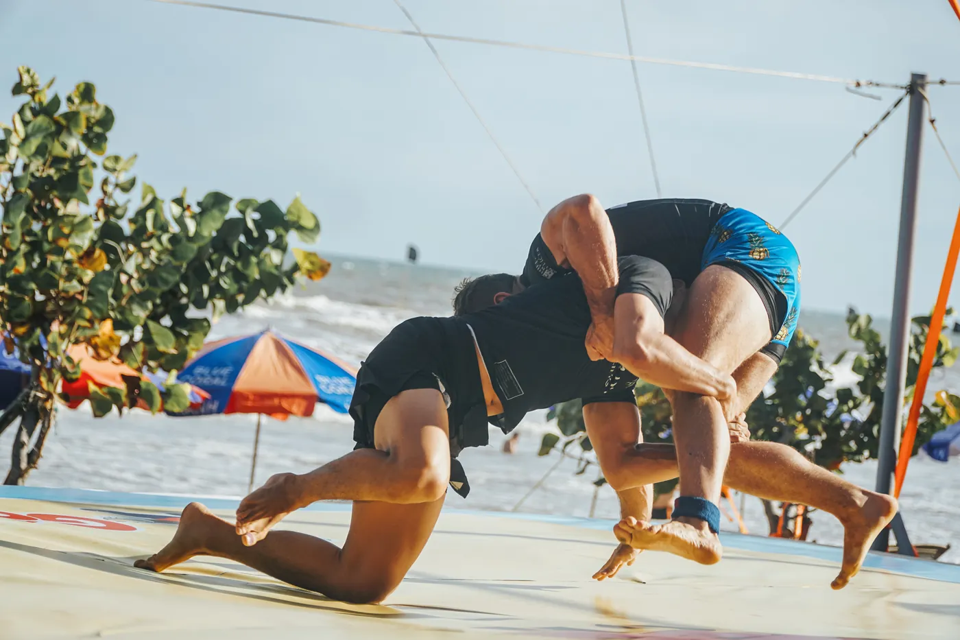 A grappler throwing a training partner on a beach in Vietnam